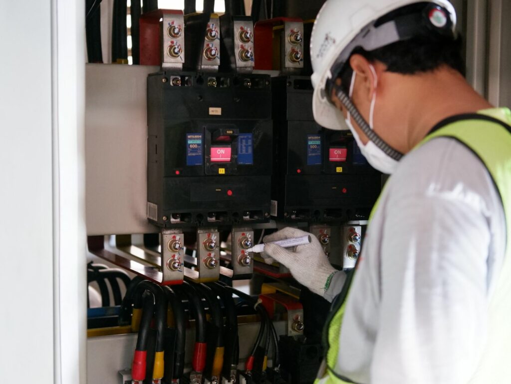 Technicien Lebel contrôlant les disjoncteurs d'une cabine haute tension lors d'un entretien préventif